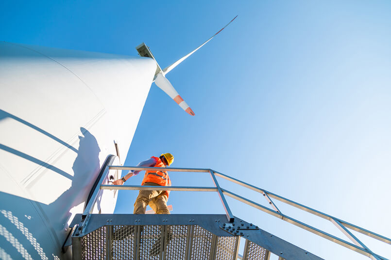 Clean_Energy_Jobs_805w Worker Inspecting a Windmill